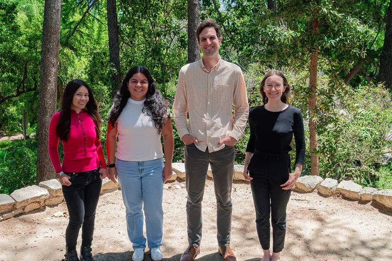 The Translational Infectious Disease Eco-epidemiology team standing in a row in front of trees